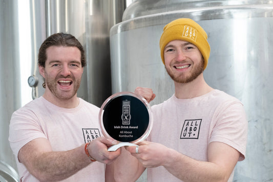 All About Kombucha co-founders proudly holding their Irish Drink Award 2022, celebrating at their Galway brewery in matching branded tees — a win for gut health, sustainability, and Irish craft kombucha.