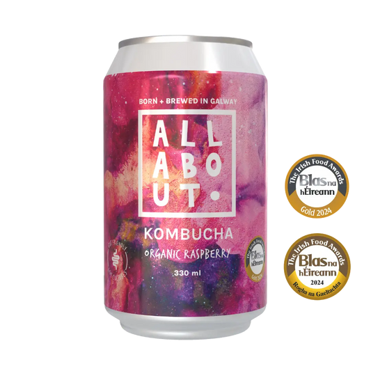 A 330 ml can of All About Organic Raspberry Kombucha. The can is shown alongside two gold Irish Food Awards from Blas na hEireann. 