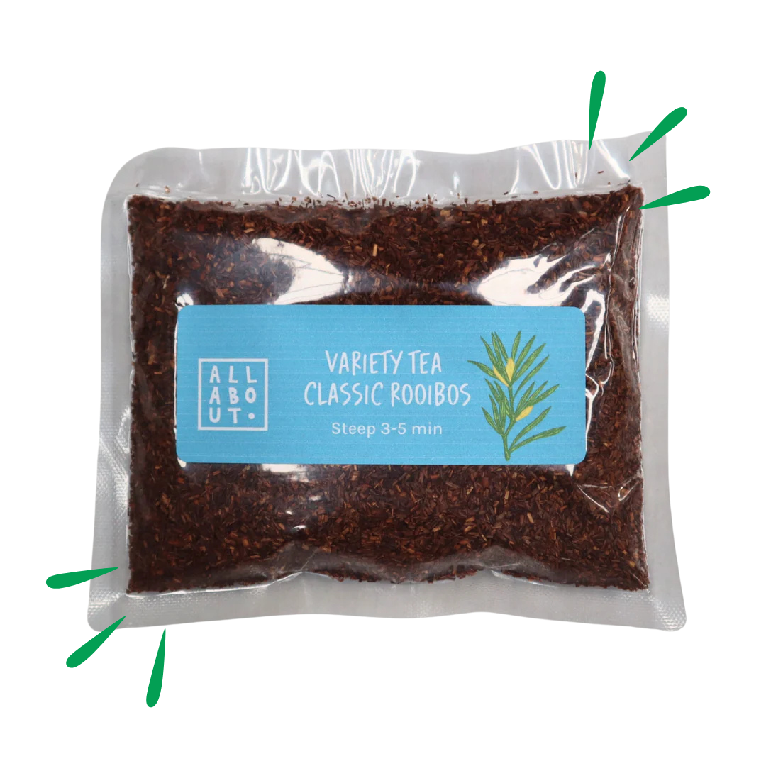 All About Kombucha variety tea pouch labeled Classic Rooibos in a clear pack with blue label, filled with finely cut red rooibos leaves and a botanical illustration.